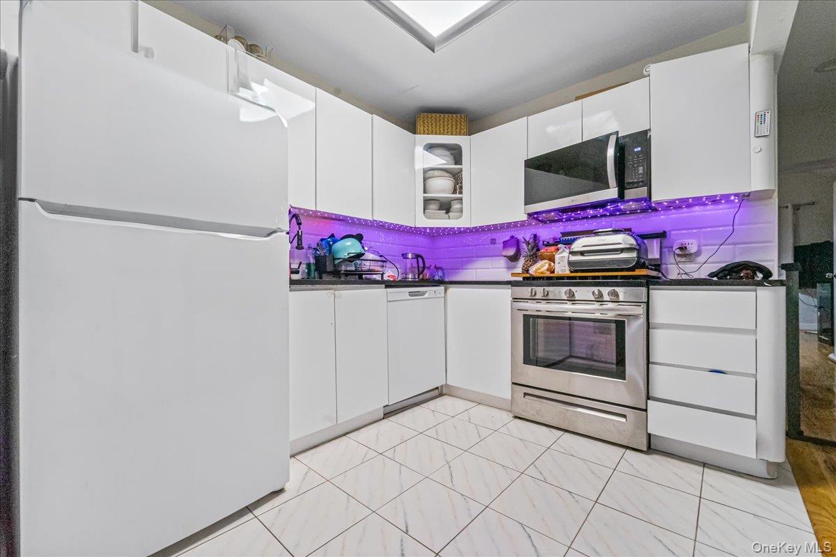 150-02 78th Road Queens, NY 11367 - Photo 8 of 23 a kitchen with stainless steel appliances granite countertop a stove a microwave and a refrigerator
