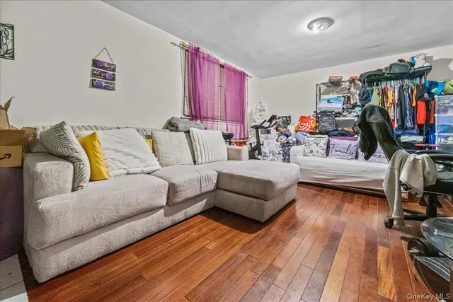 a living room with furniture a flat screen tv and gym equipment