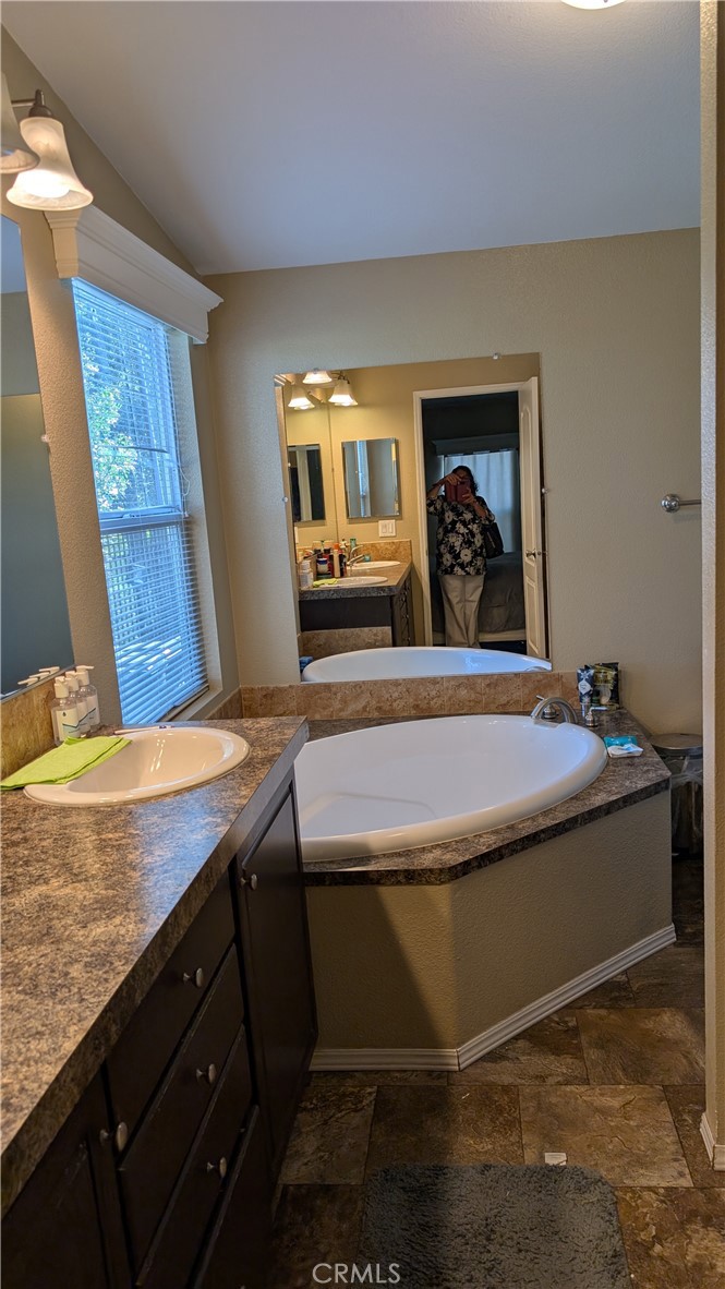 3424 West Washington Avenue, Unit 228 Santa Ana, CA 92703 - Photo 15 of 31 a bathroom with a granite countertop sink and a mirror