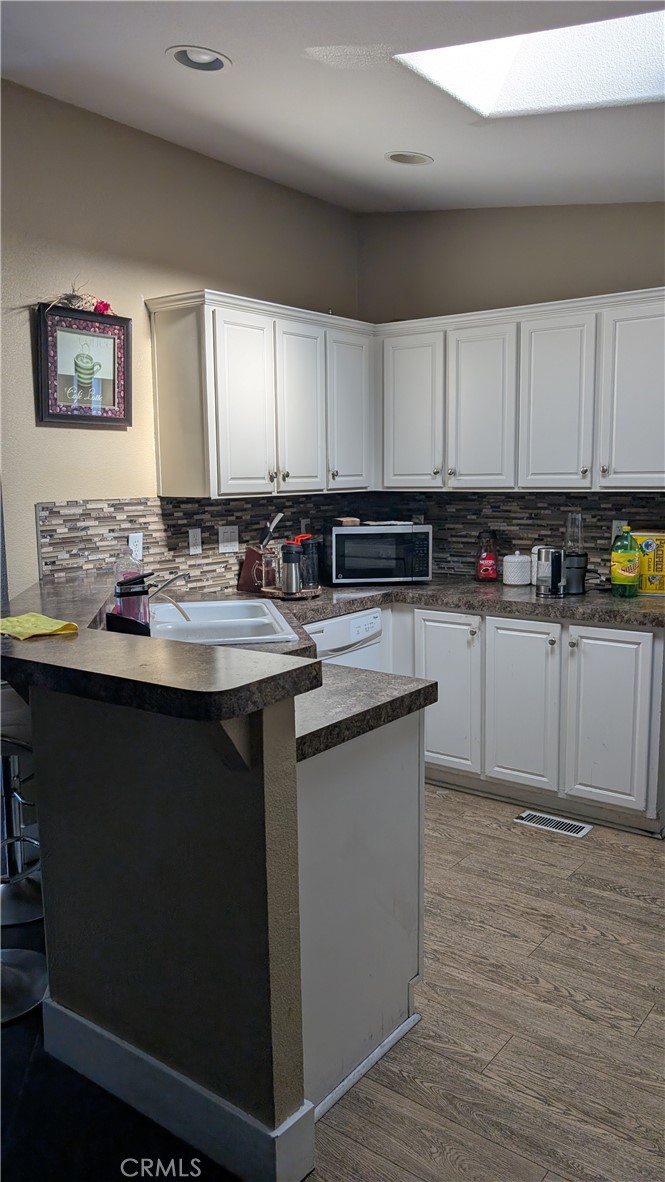 3424 West Washington Avenue, Unit 228 Santa Ana, CA 92703 - Photo 8 of 31 a kitchen with a sink cabinets and wooden floor
