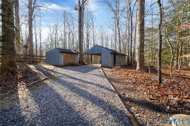 a front view of a house with a yard and covered with trees