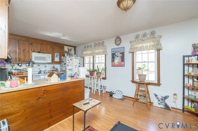 a kitchen with stainless steel appliances wooden floor dining table and chairs
