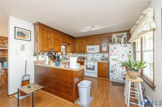 a living room with stainless steel appliances furniture a dining table and chairs
