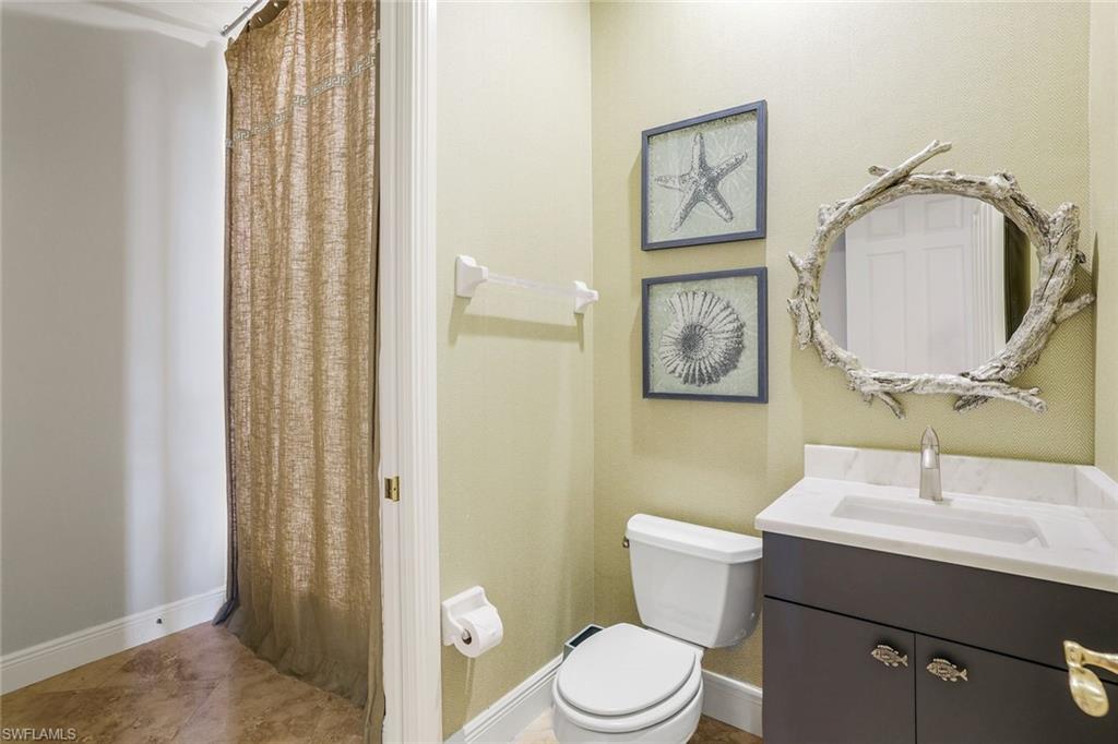 9053 Cascada Way, Unit 202 Naples, FL 34114 - Photo 18 of 45 a bathroom with a toilet a sink and mirror