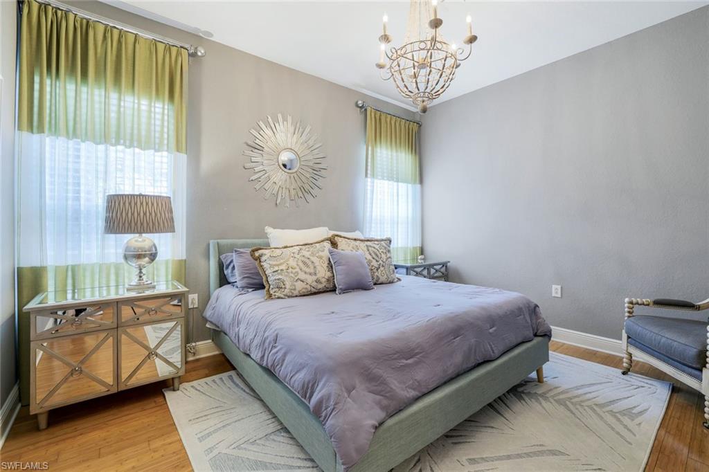 9053 Cascada Way, Unit 202 Naples, FL 34114 - Photo 21 of 45 a bedroom with a bed and a chandelier