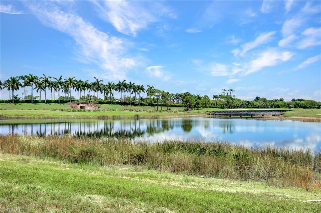 9053 Cascada Way, Unit 202 Naples, FL 34114 - Photo 39 of 45 a view of a lake with a big yard and large trees