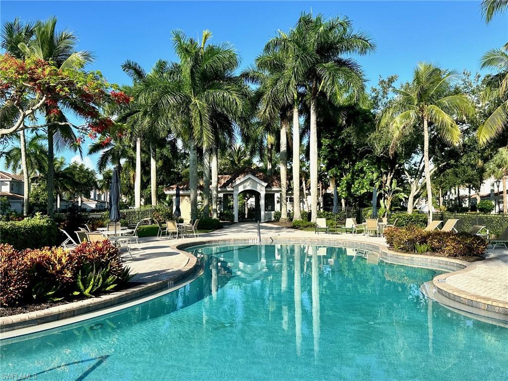 9053 Cascada Way, Unit 202 Naples, FL 34114 - Photo 45 of 45 a view of a swimming pool with a garden and palm trees