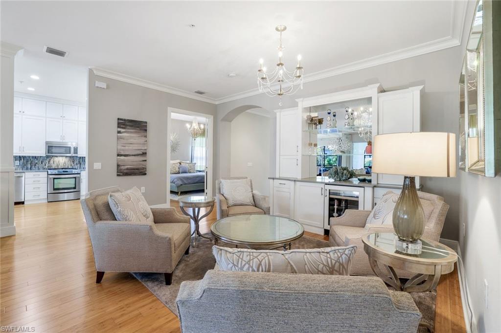 9053 Cascada Way, Unit 202 Naples, FL 34114 - Photo 5 of 45 a living room with furniture and a chandelier