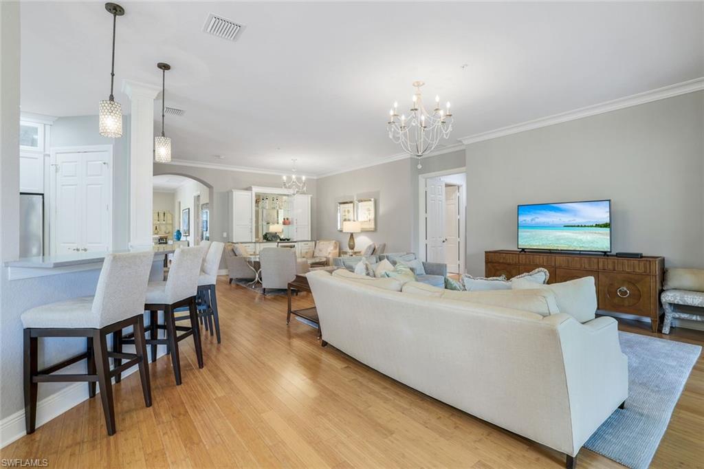 9053 Cascada Way, Unit 202 Naples, FL 34114 - Photo 7 of 45 a living room with couches chairs and kitchen view with wooden floor
