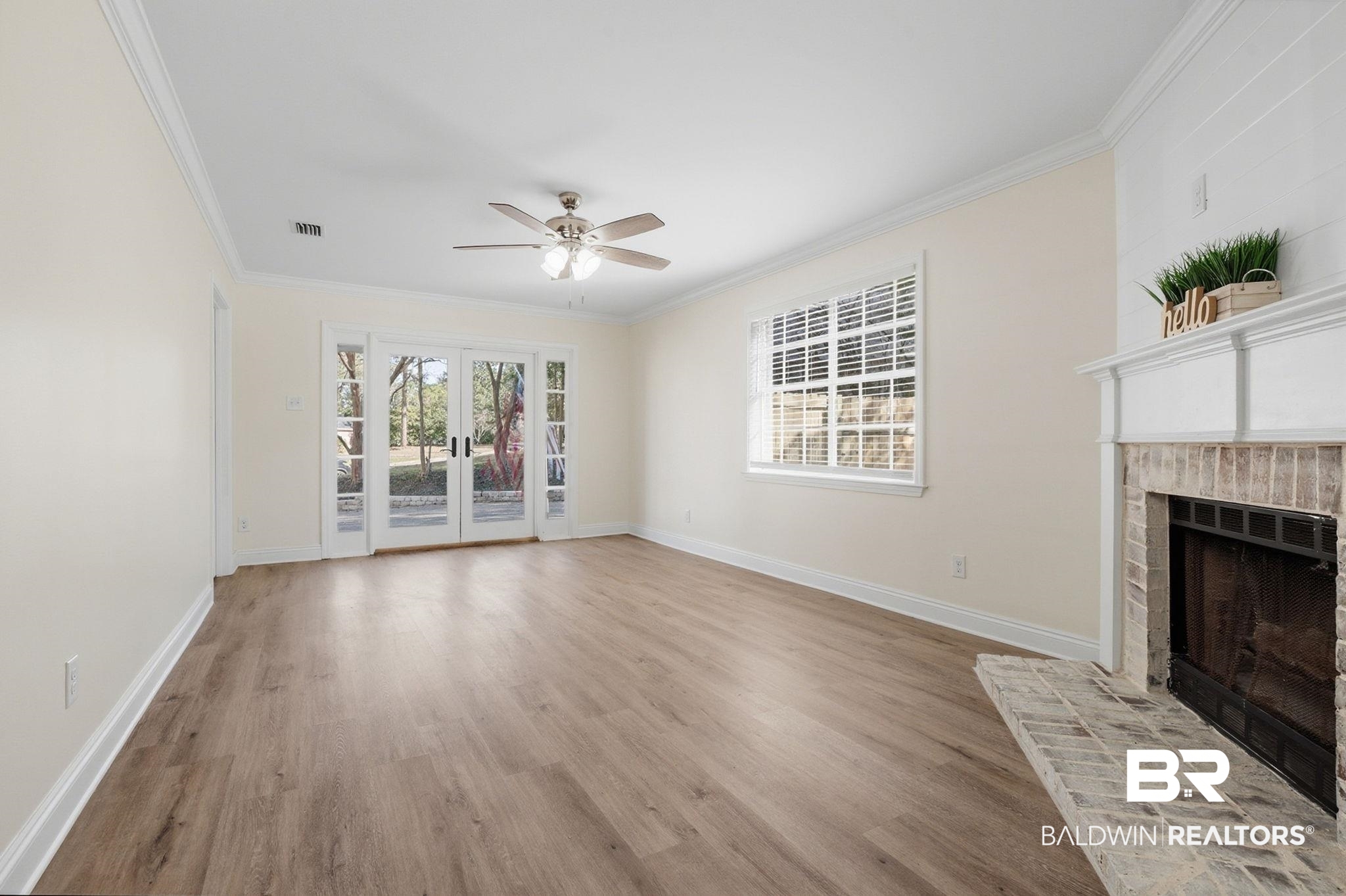 814 Nassau Drive Mobile, AL 36608 - Photo 8 of 44 Unfurnished living room with light wood-type flooring, a fireplace, ornamental molding, a ceiling fan, and french doors