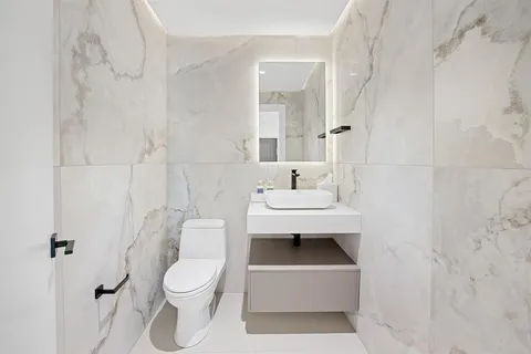a white toilet sitting next to a bathroom sink