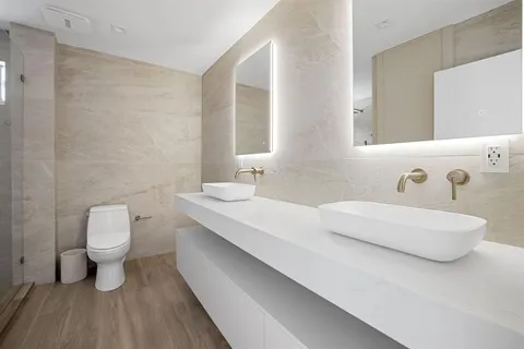 a bathroom with a double vanity sink mirror and toilet