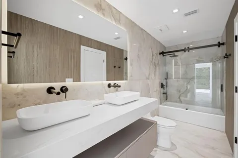 a bathroom with a double vanity sink mirror double and bathtub