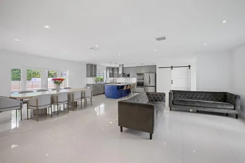 a living room with furniture and a dining table with chairs