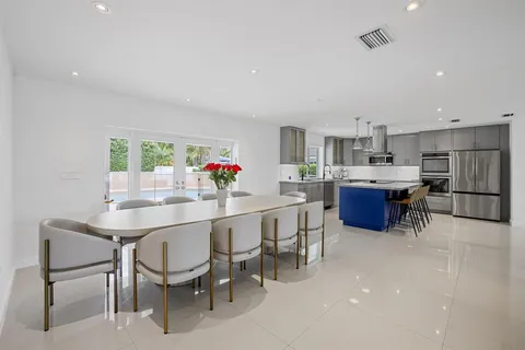 a kitchen with stainless steel appliances a table and chairs in it