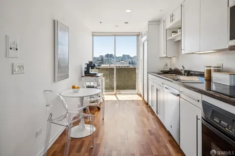 a kitchen with stainless steel appliances granite countertop a stove top oven a sink dishwasher and cabinets with wooden floor