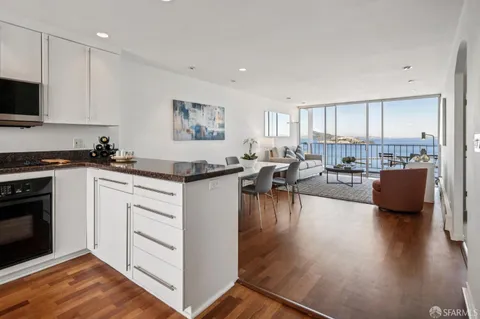 a kitchen with white cabinets and a wooden floor