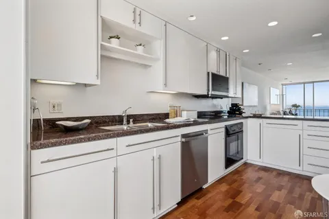 a kitchen with stainless steel appliances granite countertop a sink and a stove