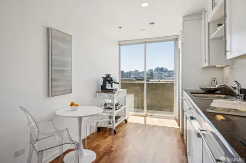 a kitchen with stainless steel appliances granite countertop a stove a sink a dining table and chairs