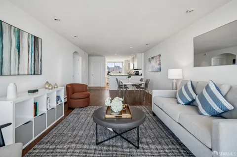 a living room with furniture a rug and a table