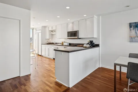 a kitchen with stainless steel appliances granite countertop a stove a sink a refrigerator and a microwave