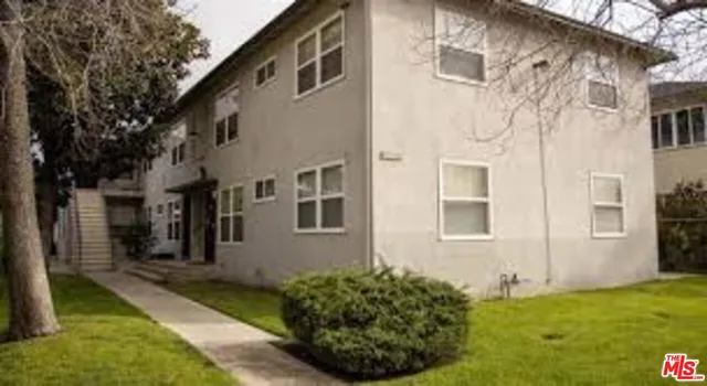 a view of a white house next to a yard