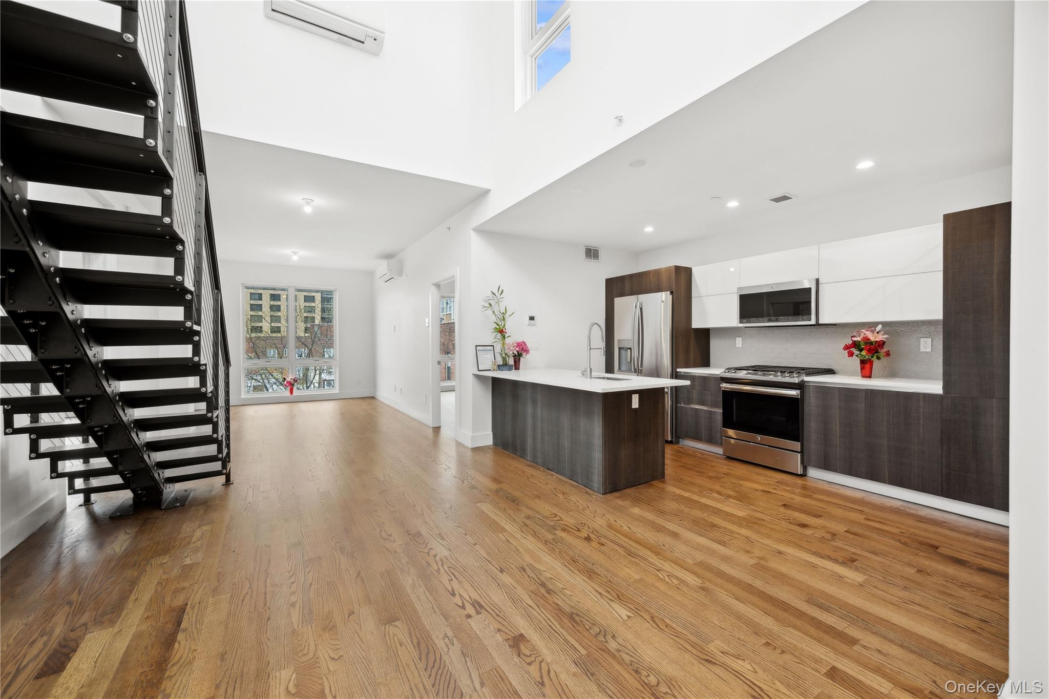 109-19 72nd Road, Unit PH7F Queens, NY 11375 - Photo 27 of 27 a large kitchen with stainless steel appliances kitchen island a large counter top and a stove top oven
