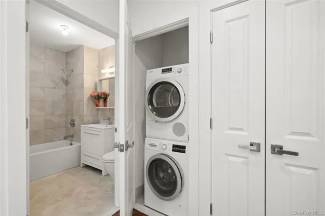 a utility room with dryer washer and a view of bathroom