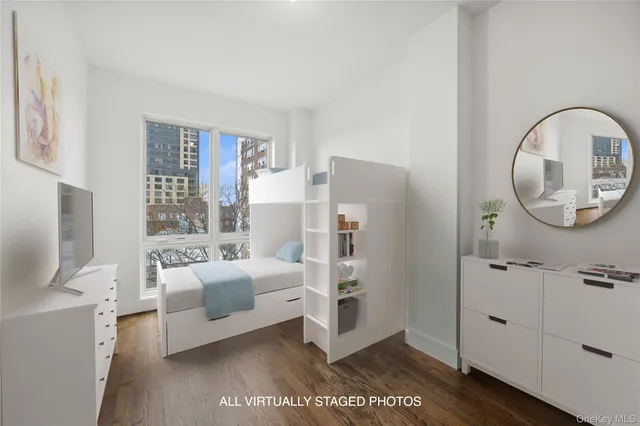 a living room with furniture a mirror and white walls