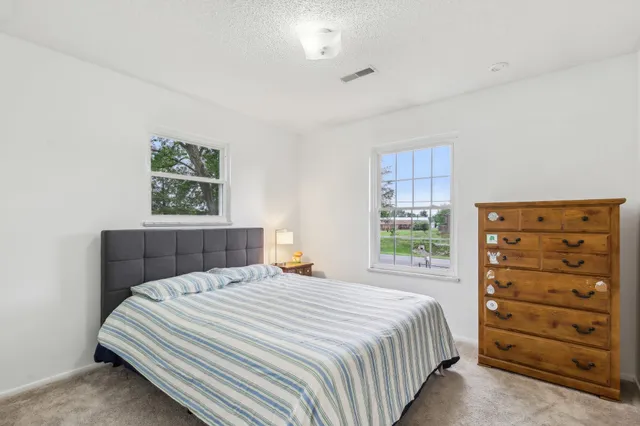 a spacious bedroom with a bed couch and window