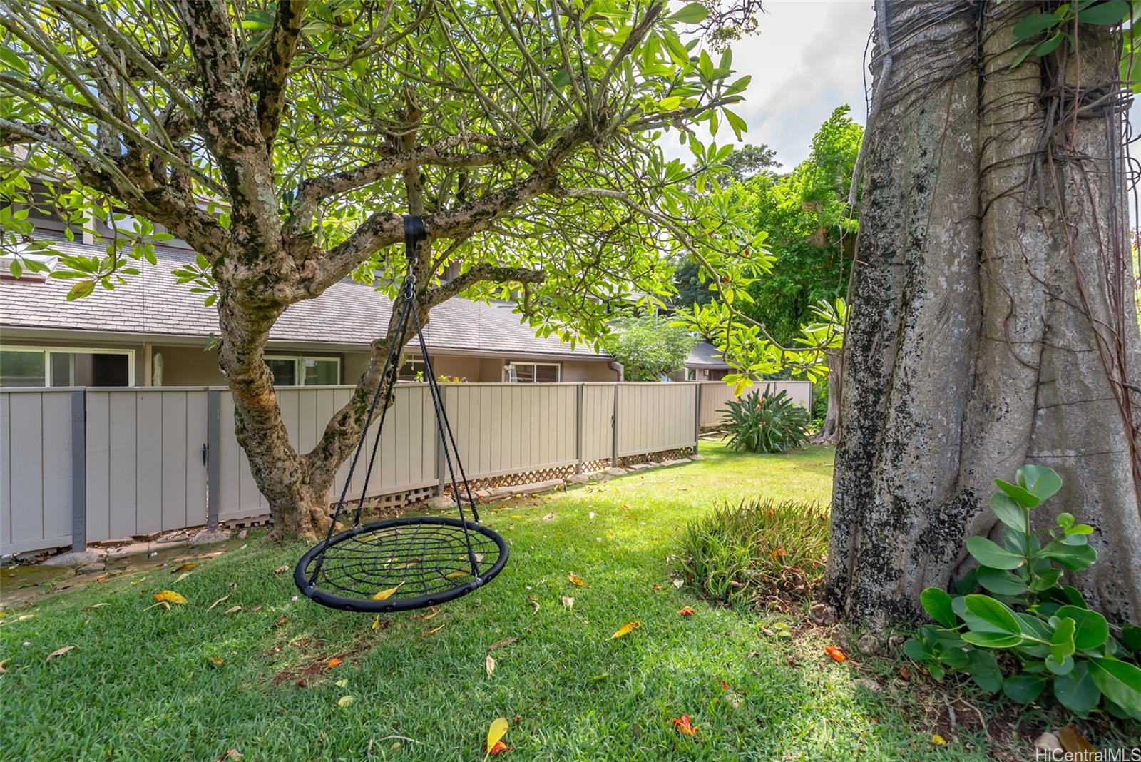 45-995 Wailele Road, Unit 55 Kaneohe, HI 96744 - Photo 17 of 24 a view of a backyard with table and chairs a barbeque and a large tree