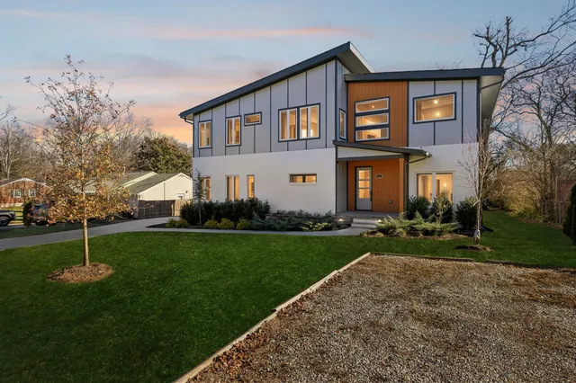 a front view of house with yard and trees in the background