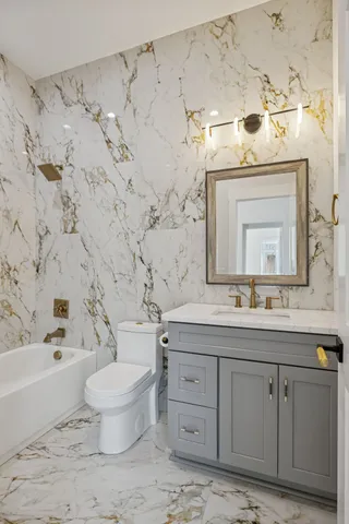 a bathroom with a sink toilet vanity and shower