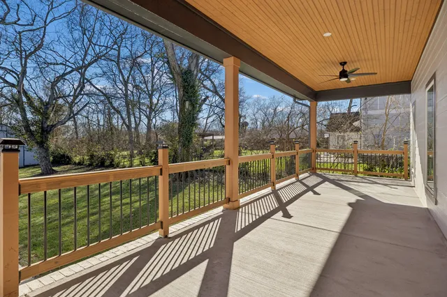 an aerial view of a residential houses with outdoor space and trees