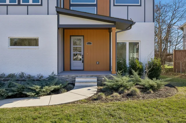 a view of an empty room with wooden floor and stairs