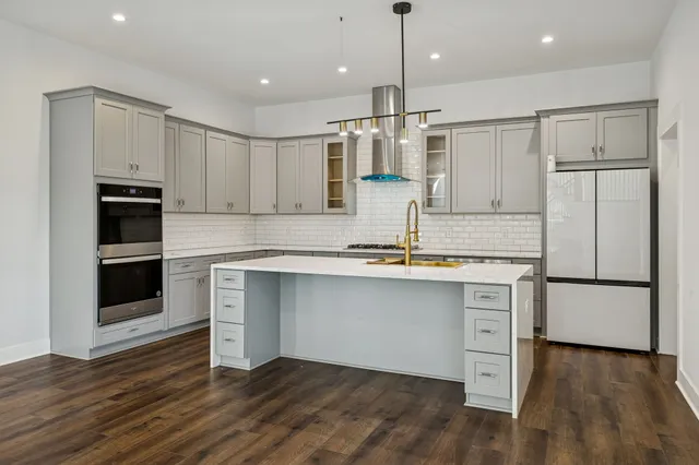a view of an empty room with wooden floor fireplace and a window