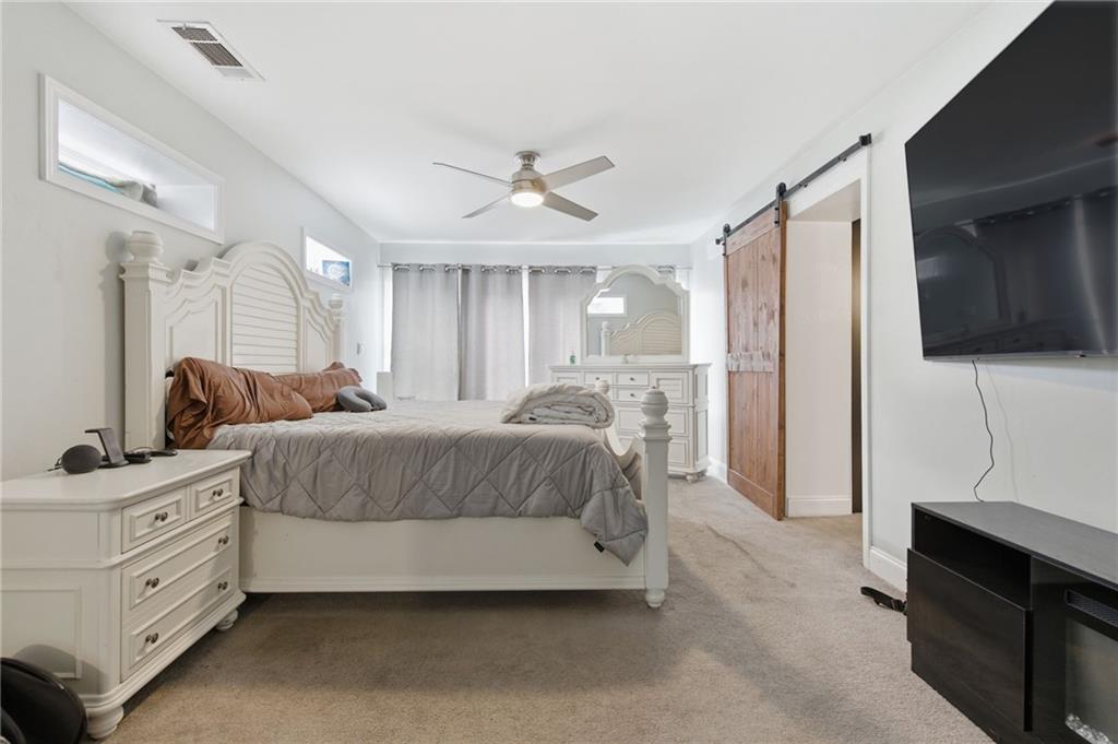 1690 Ware Avenue Atlanta, GA 30344 - Photo 18 of 25 a spacious bedroom with a bed and a flat screen tv