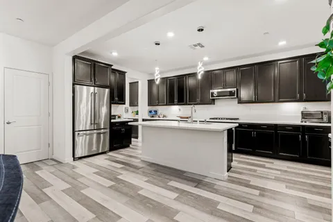 a kitchen with stainless steel appliances granite countertop a sink stove and refrigerator