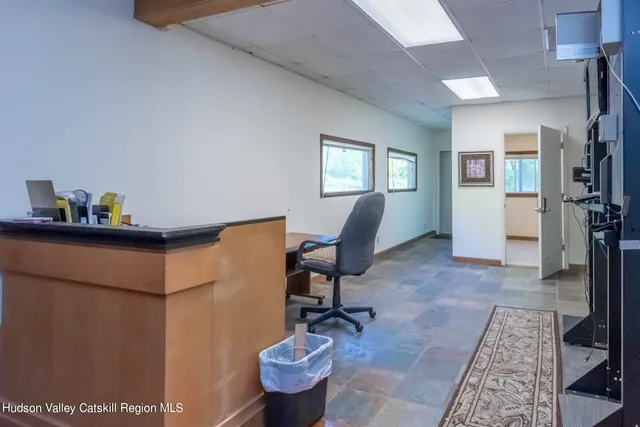 a view of a workspace with furniture and a window