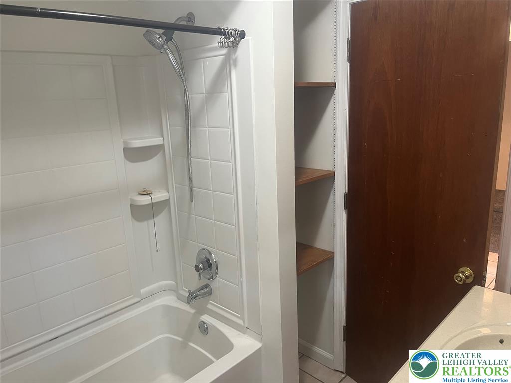 1839 Willow Park Road Bethlehem, PA 18020 - Photo 16 of 35 A well-maintained tub and shower combination with convenient built-in shelving offer practical bathroom solutions.