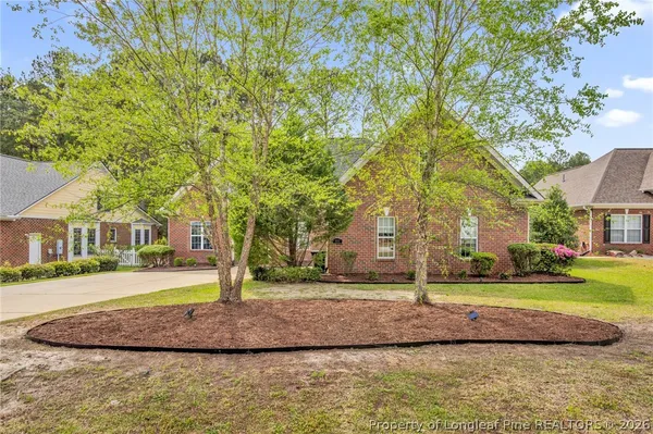 a view of a house with a yard and large trees
