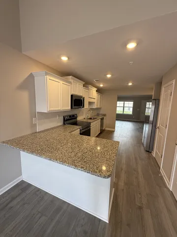 a view of kitchen with sink microwave and refrigerator