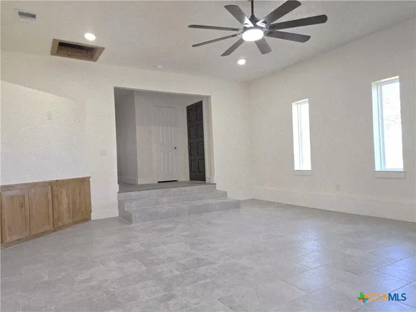 a large kitchen with stainless steel appliances wooden floor and a refrigerator