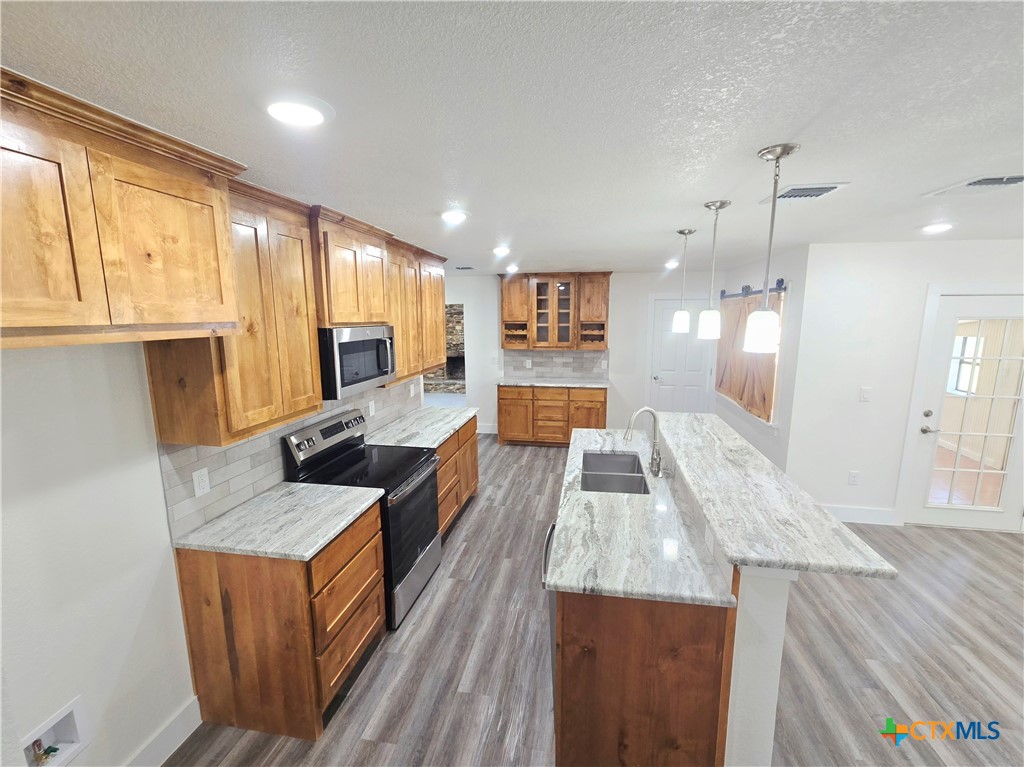 132 County Road 4765 Kempner, TX 76539 - Photo 16 of 36 a large kitchen with stainless steel appliances wooden floor and a refrigerator