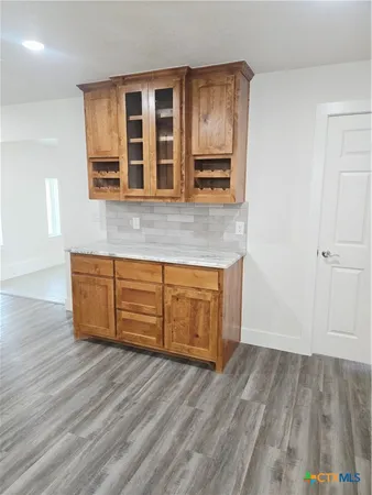 an empty room with windows and fireplace