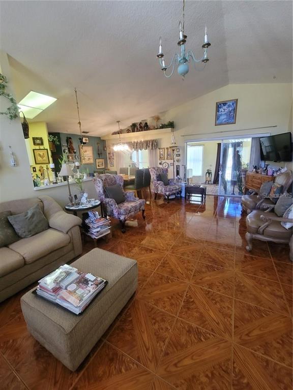 8430 Madrid Road Weeki Wachee, FL 34613 - Photo 3 of 11 a living room with furniture or couch and a chandelier