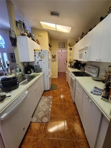 a kitchen with stainless steel appliances granite countertop a sink a stove and a refrigerator