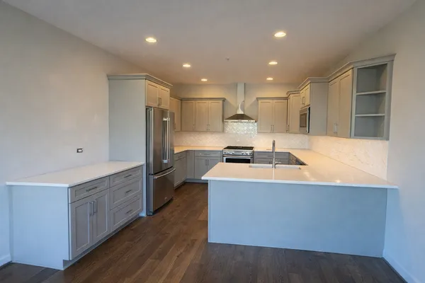 a kitchen with kitchen island stainless steel appliances a sink a stove a refrigerator and a center island