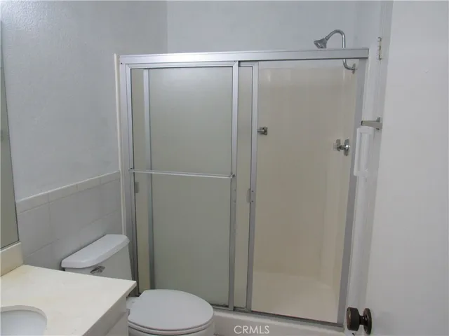 a white toilet sitting next to a shower