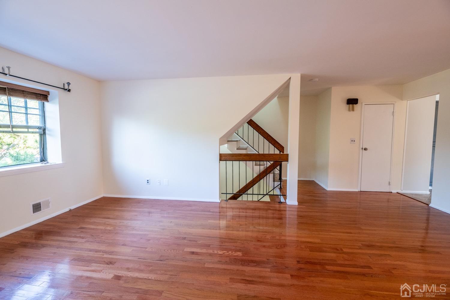 7101 Hana Road Edison, NJ 08817 - Photo 11 of 77 a view of an empty room with wooden floor and a window